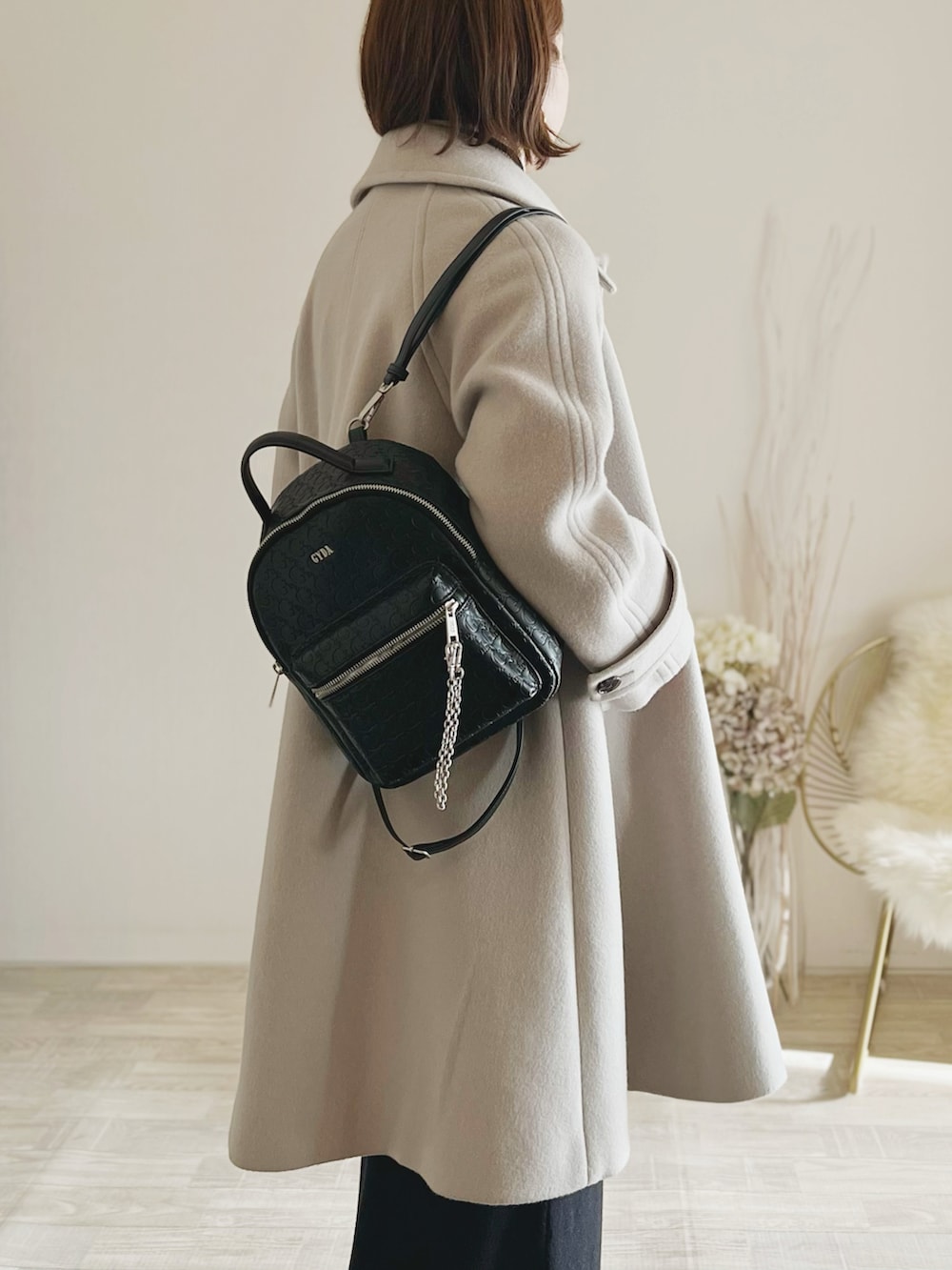 ブラック系のバックパック/リュック、グレー系のピーコート、ブラック系のスカートを着用したレディースの冬コーディネートの2枚目の写真