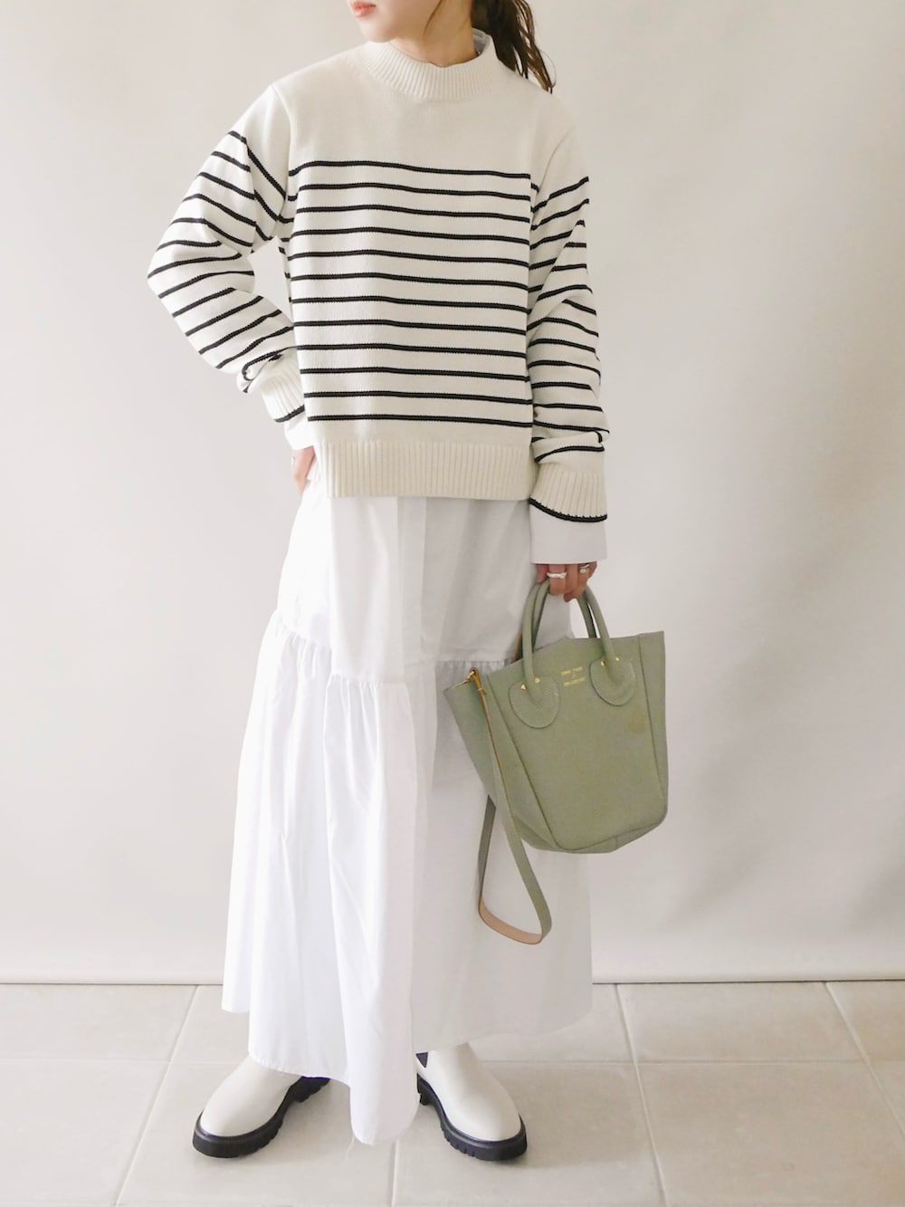 ホワイト系のワンピース/ドレス、ホワイト系のトップス、ブラウン系のバッグを着用したレディースの冬コーディネートの3枚目の写真