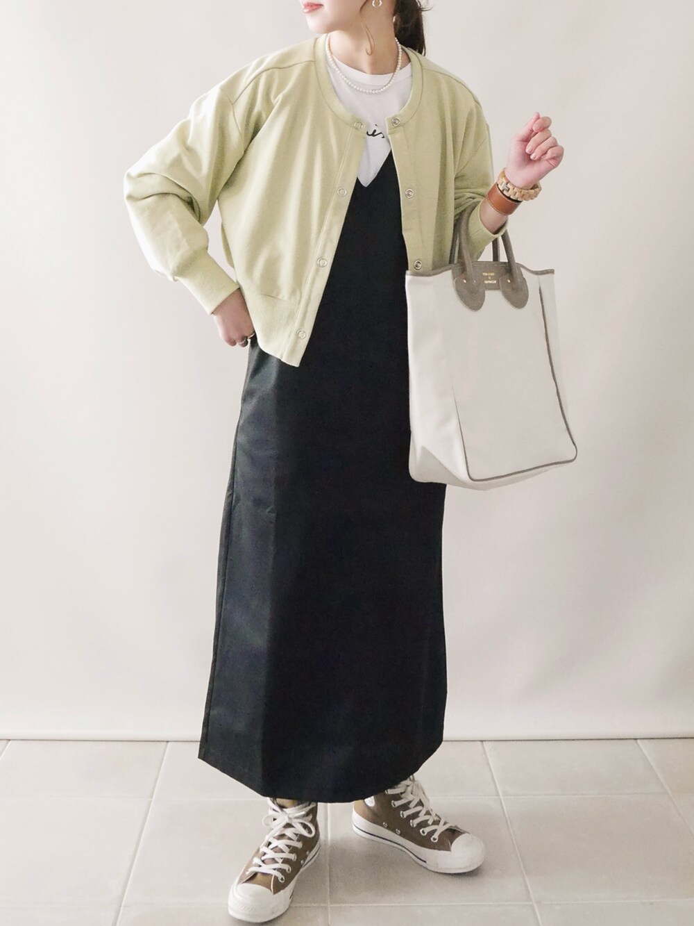 グリーン系のカーディガン/ボレロ、ブラック系のジャンパースカート、ブラウン系の口紅/リップティント/グロスを着用したレディースの冬コーディネートの3枚目の写真