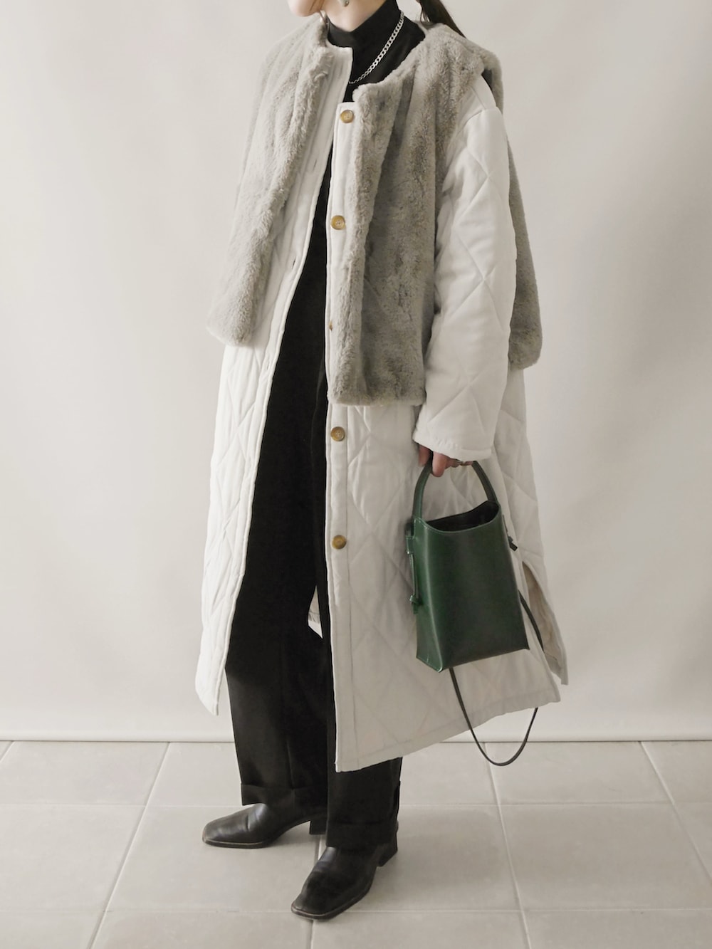 ベージュ系のその他アウター、ブラック系のトップス、ブラック系のその他パンツを着用したレディースの冬コーディネートの2枚目の写真