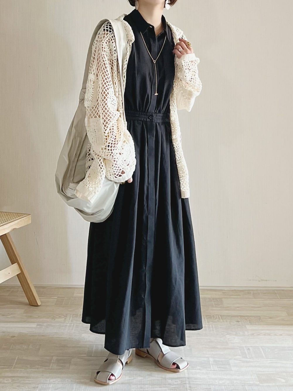 ブラック系のワンピース、ホワイト系のブルゾン、ホワイト系のバッグを着用したレディースの春コーディネートの2枚目の写真