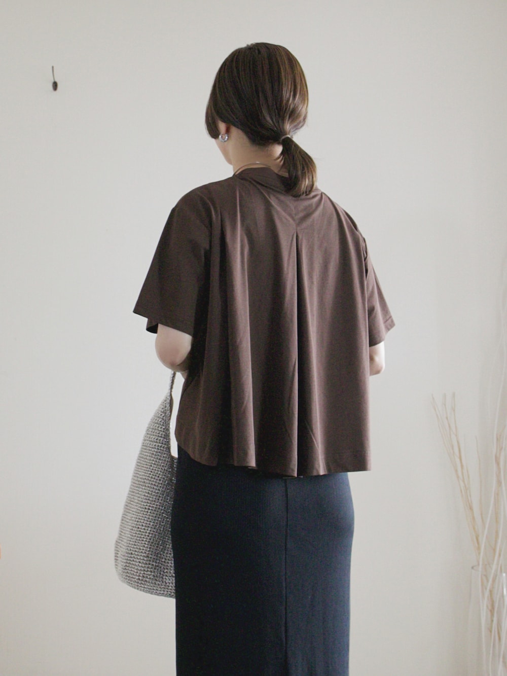 ブラック系のスカート、ブラウン系のTシャツ/カットソー、ブラック系のサンダルを着用したレディースの夏コーディネートの2枚目の写真