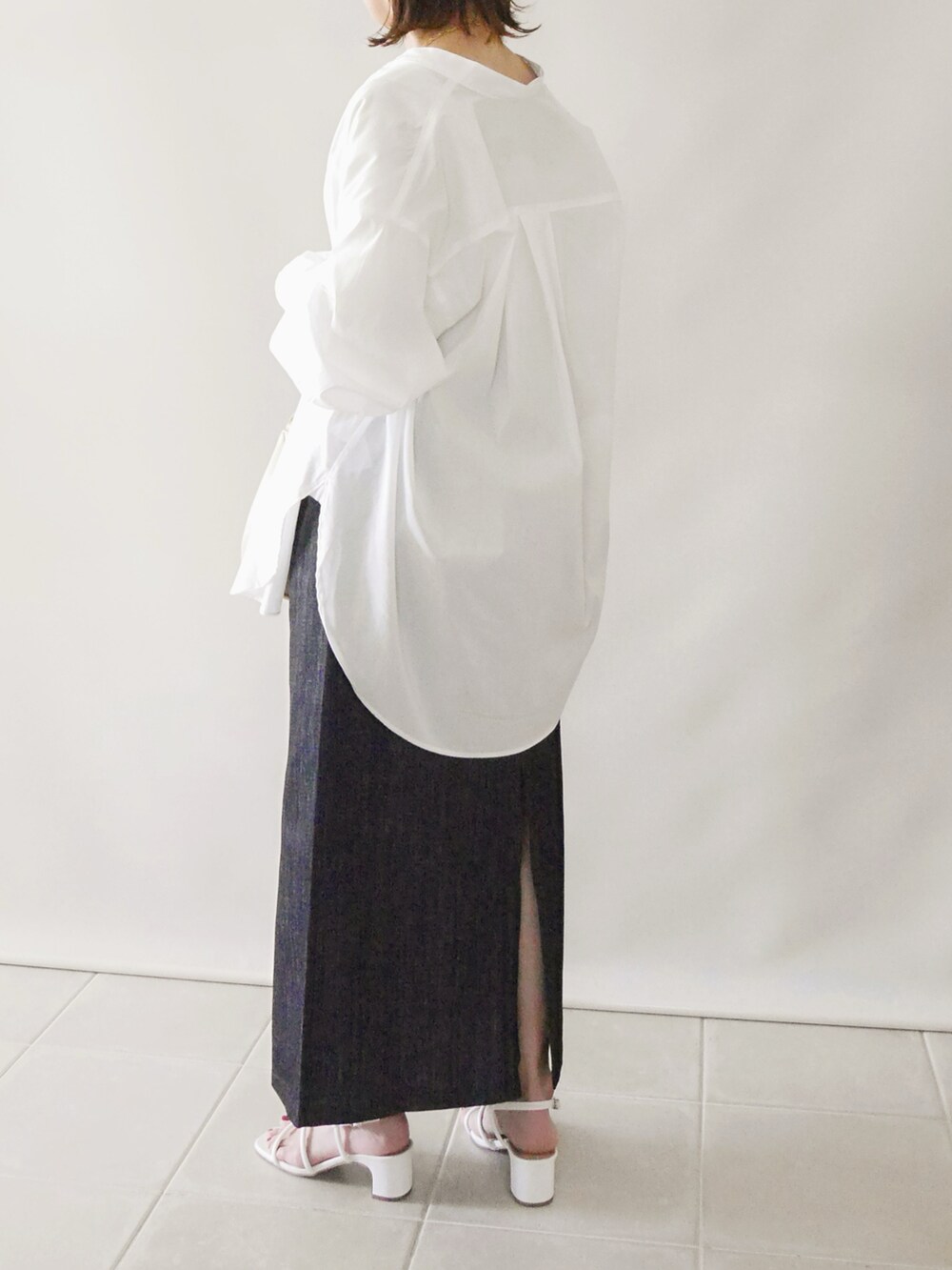 ホワイト系のサンダル、ブルー系のスカート、ベージュ系のタンクトップを着用したレディースの春コーディネートの3枚目の写真