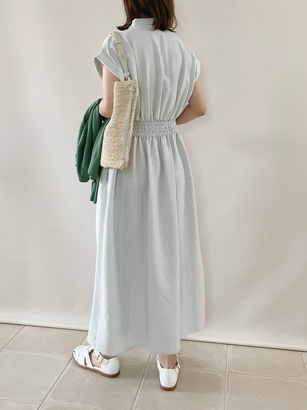 グリーン系のワンピース、グリーン系のトップス、ベージュ系のショルダーバッグを着用したレディースの春コーディネートの3枚目の写真