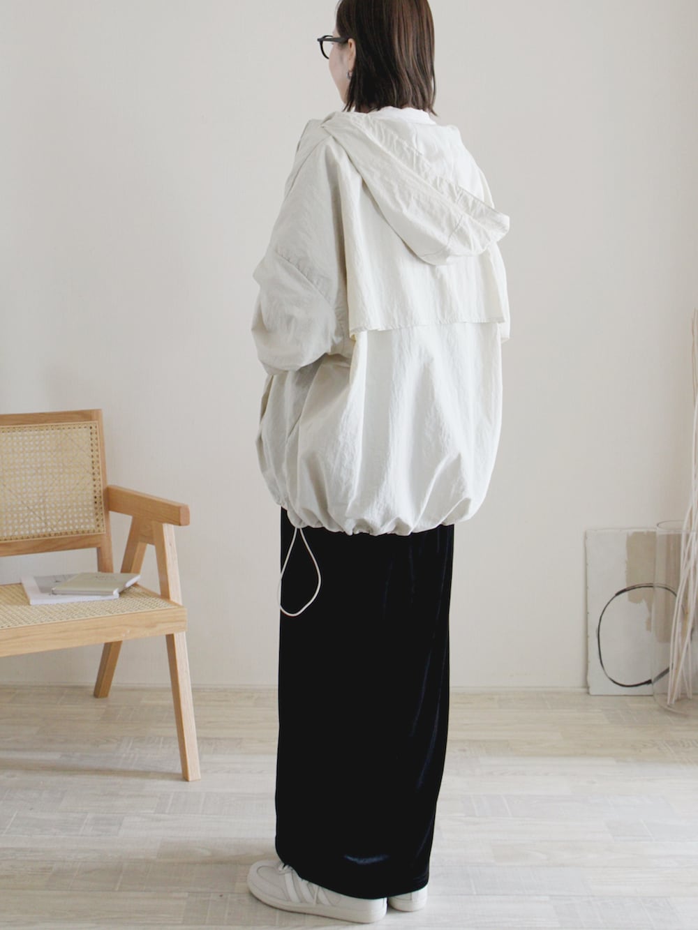 ホワイト系のマウンテンパーカー、ブラック系のスカート、ブラック系のショルダーバッグを着用したレディースの秋コーディネートの2枚目の写真