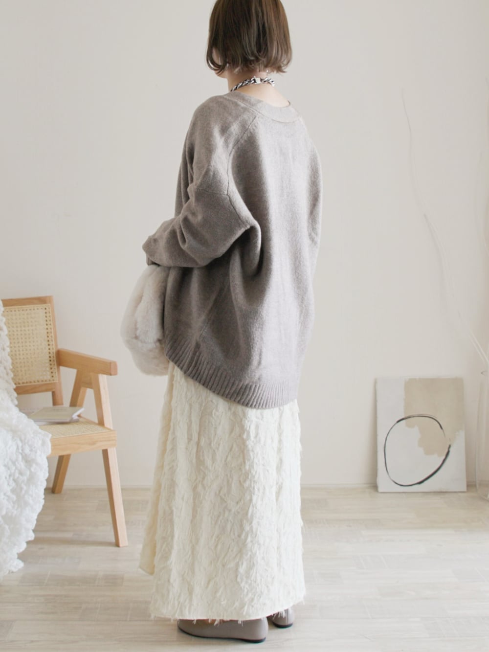 ベージュ系のカーディガン/ボレロ、ホワイト系のワンピース、ベージュ系のバレエシューズを着用したレディースの秋コーディネートの2枚目の写真