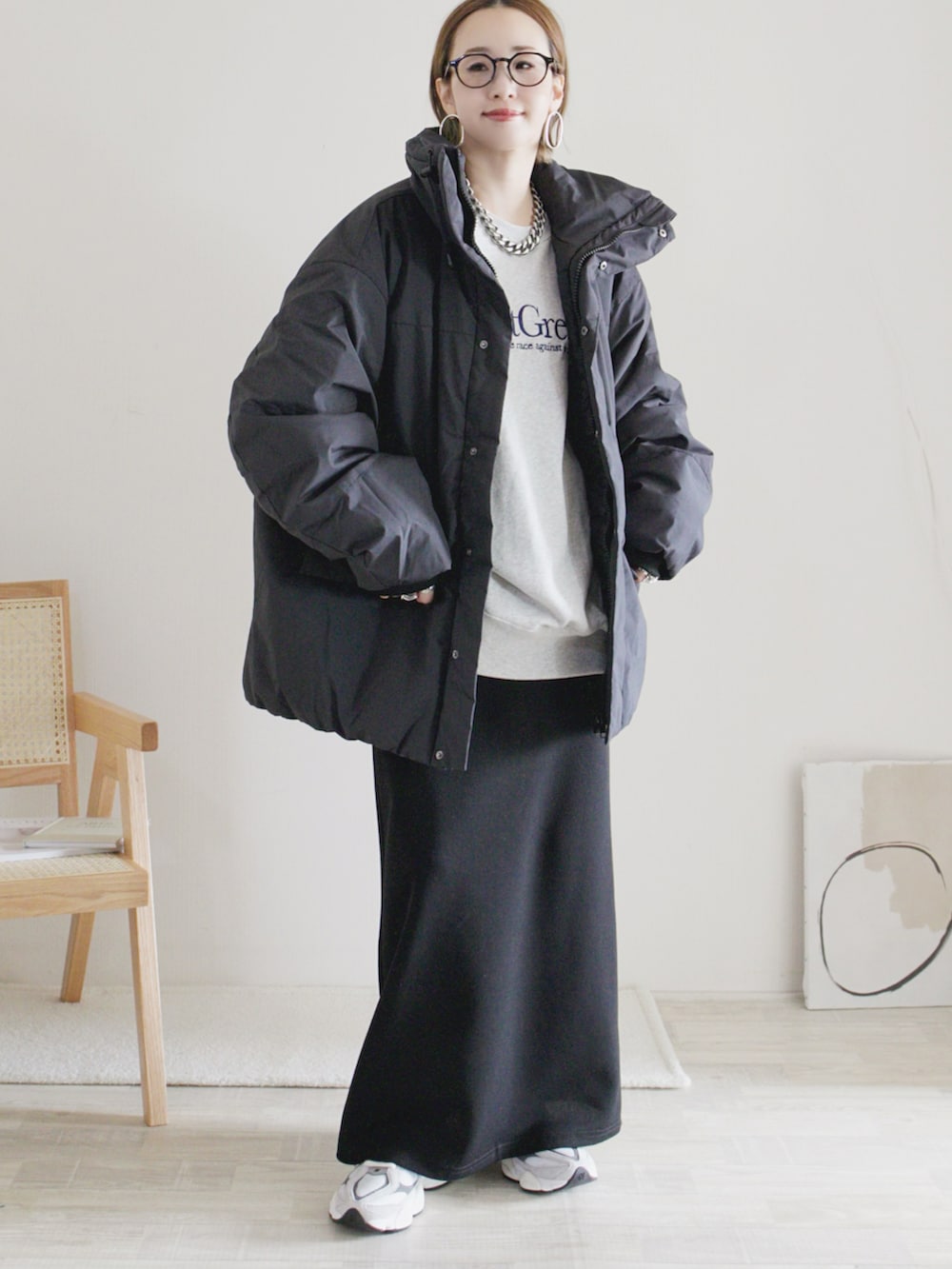 ブラック系のダウンジャケット/コート、グレー系のスウェット、ブラック系のスカートを着用したレディースの秋コーディネートの2枚目の写真