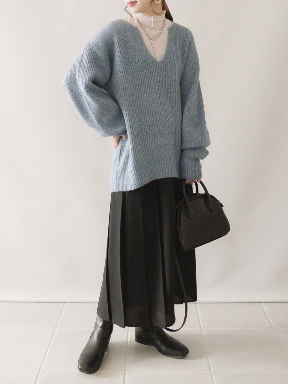 ブルー系のニット/セーター、ブラック系のスカート、ブラック系のシューズを着用したレディースの秋コーディネートの2枚目の写真