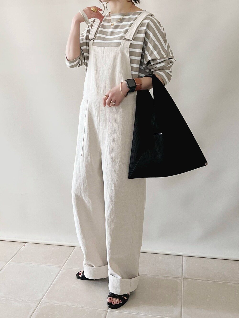 グレー系のTシャツ/カットソー、ベージュ系のサロペット/オーバーオール、ブラック系のハンドバッグを着用したレディースの春コーディネートの2枚目の写真