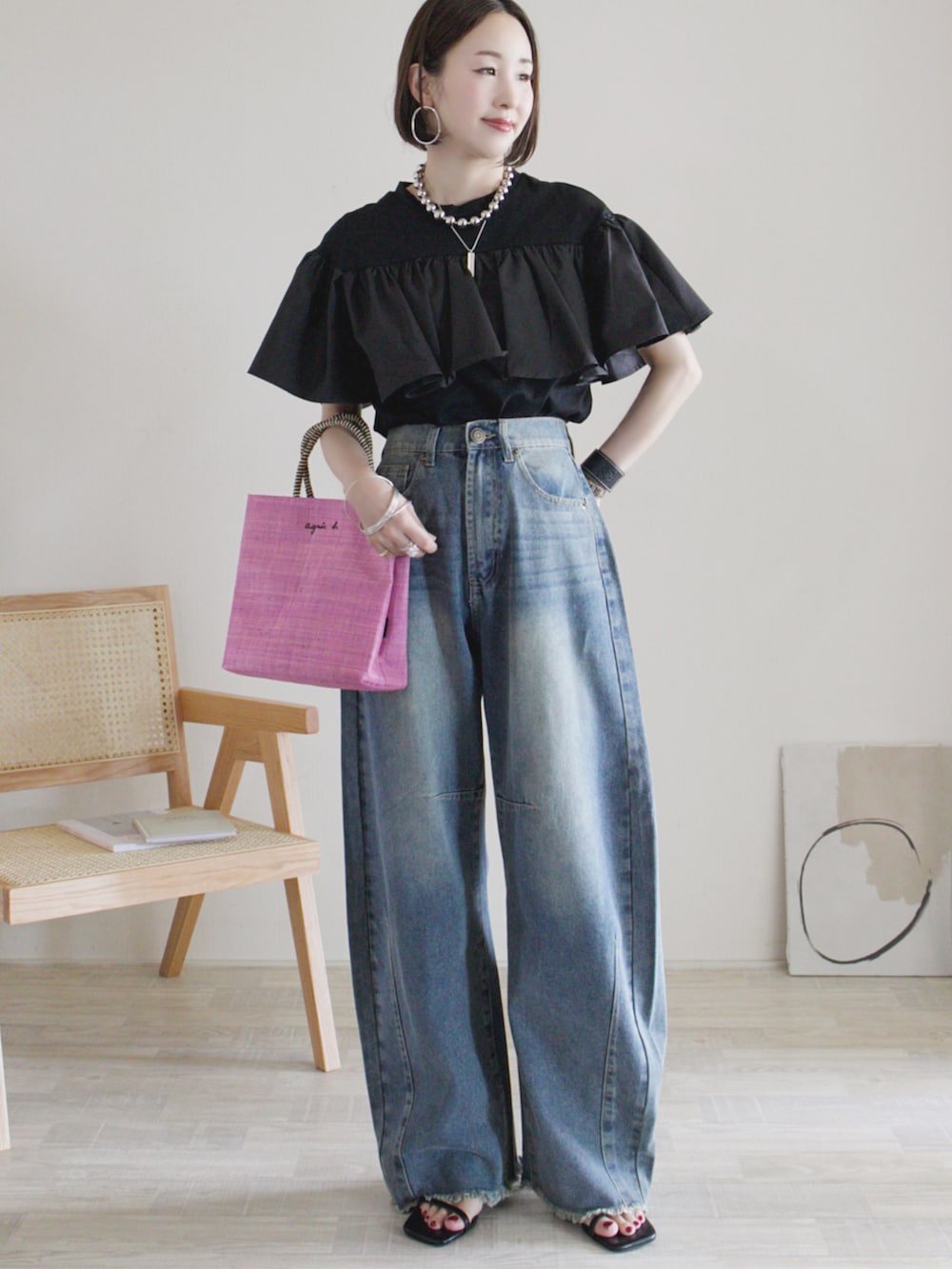 ブルー系のデニムパンツ、ブラック系のTシャツ/カットソー、ピンク系のハンドバッグを着用したレディースの夏コーディネートの2枚目の写真