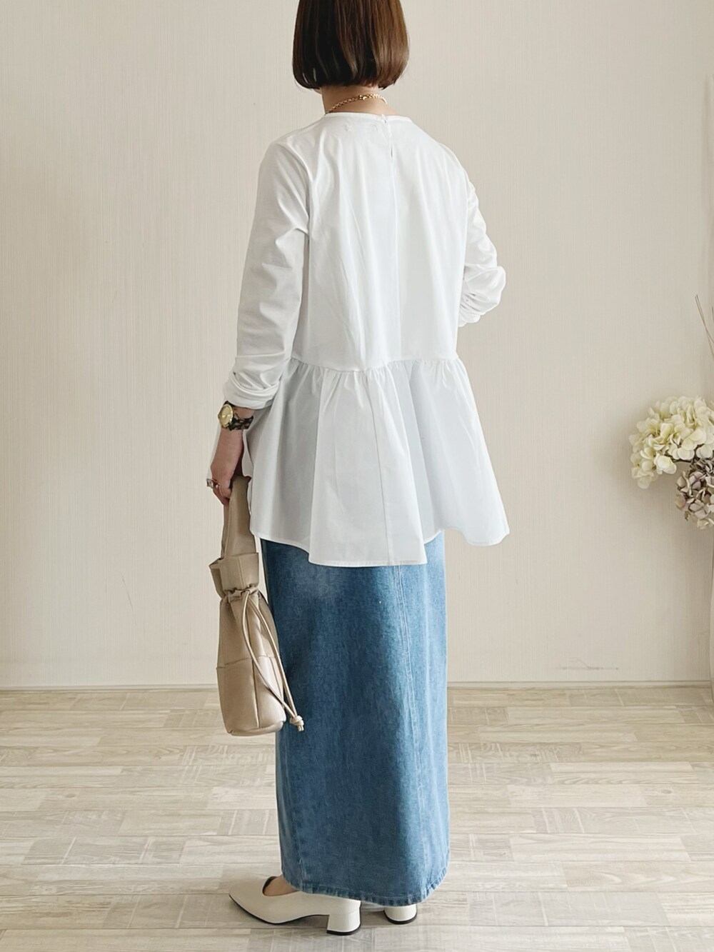 ホワイト系のTシャツ/カットソー、ブルー系のスカート、ベージュ系のバッグを着用したレディースの春コーディネートの2枚目の写真