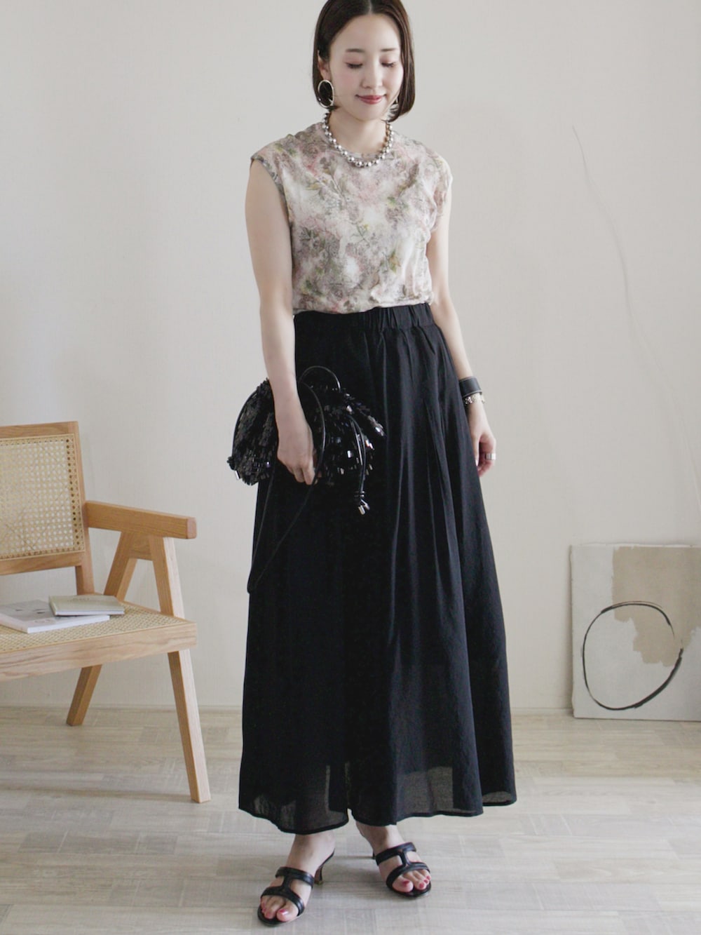 ピンク系のTシャツ/カットソー、ブラック系のその他パンツ、ブラック系のクラッチバッグを着用したレディースの夏コーディネートの2枚目の写真