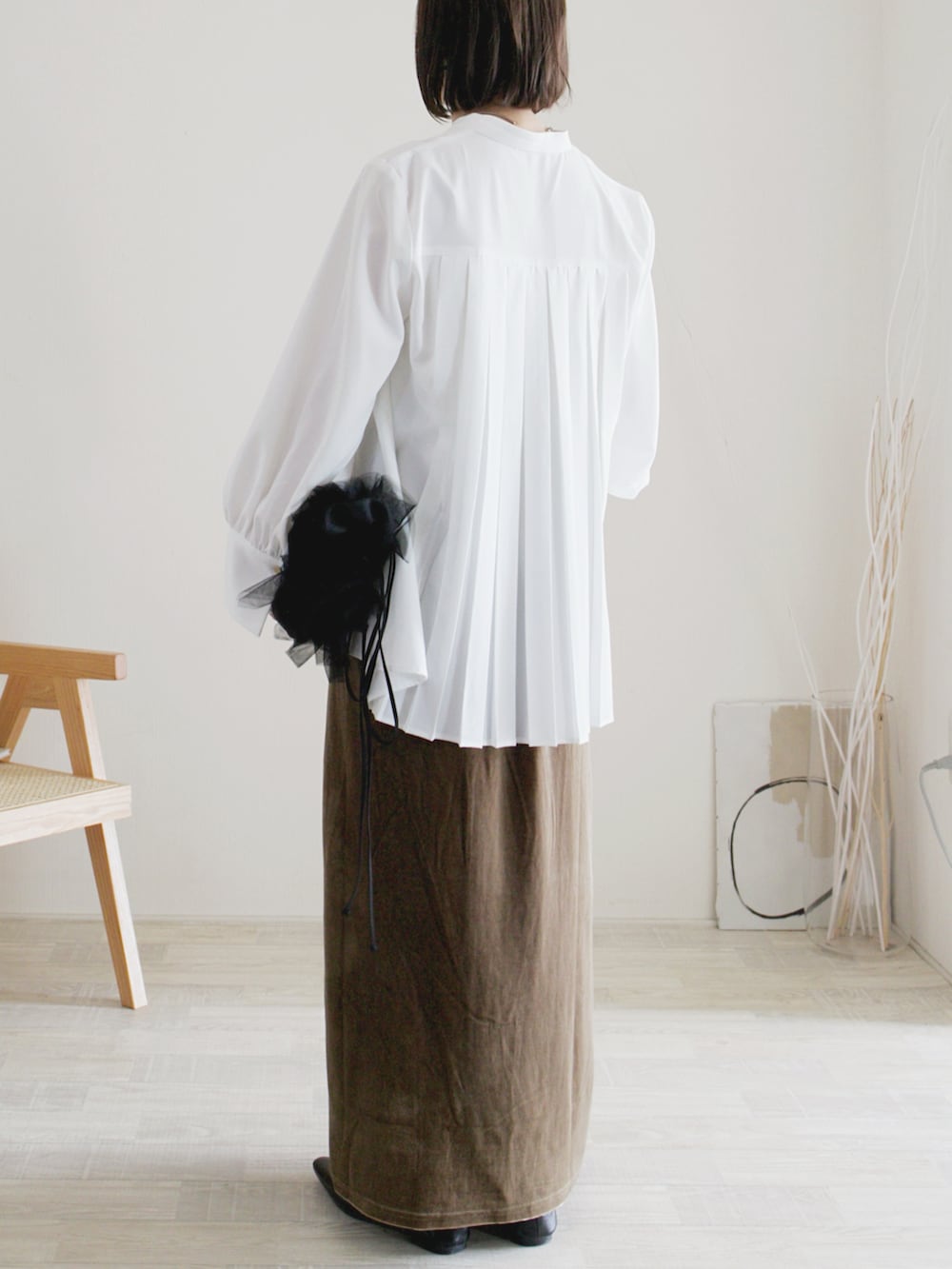 グリーン系のスカート、ホワイト系のシャツ/ブラウス、ブラック系のパンプスを着用したレディースの秋コーディネートの2枚目の写真