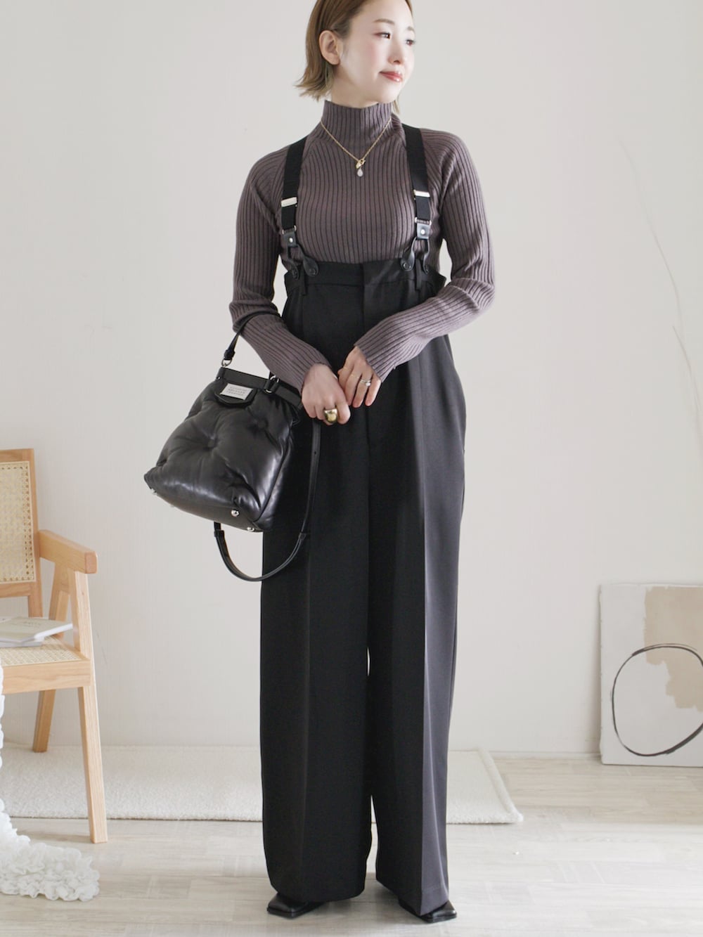 グレー系のニット/セーター、ブラック系のその他パンツ、ブラック系のショルダーバッグを着用したレディースの秋コーディネートの2枚目の写真