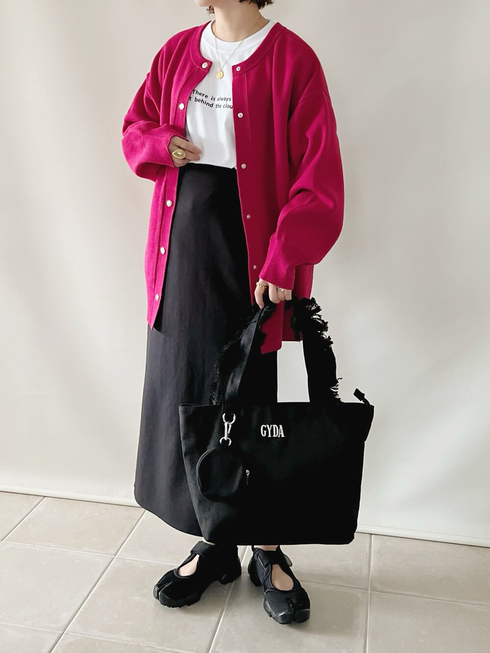 ブラック系のトートバッグ、レッド系のトップス、ホワイト系のTシャツ/カットソーを着用したレディースの夏コーディネートの2枚目の写真