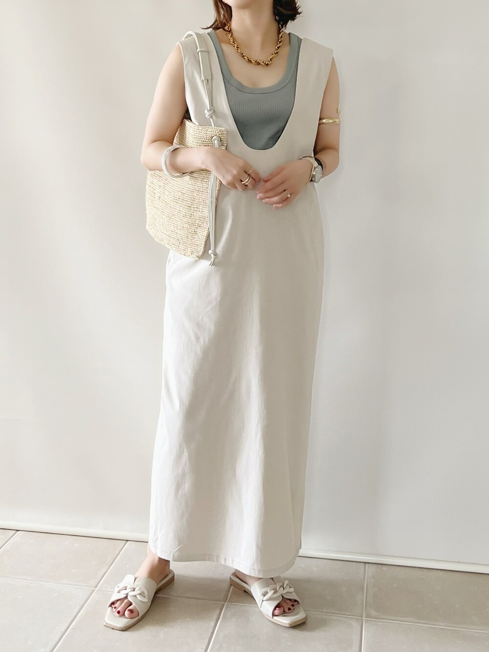 ベージュ系のジャンパースカート、グリーン系のトップス、ホワイト系のシューズを着用したレディースの夏コーディネートの3枚目の写真