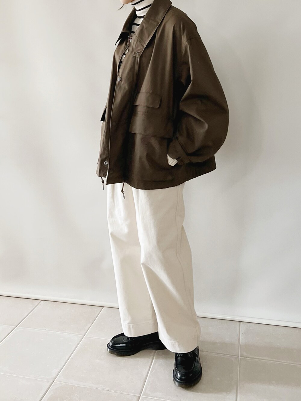 ブラウン系のジャケット/アウター、ホワイト系のパンツ、ホワイト系のトップスを着用したレディースの秋コーディネートの2枚目の写真