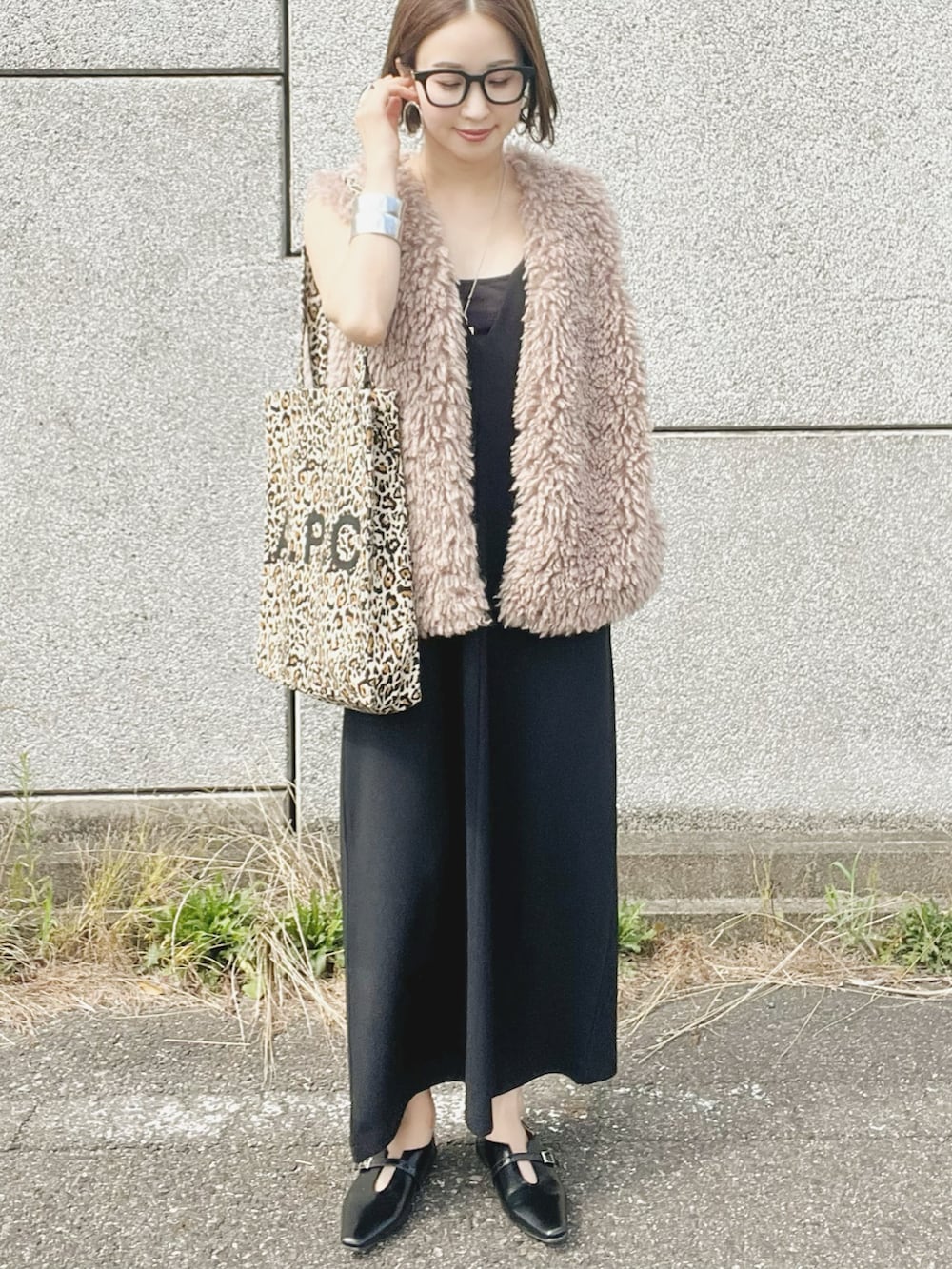 ベージュ系のベスト、ブラック系のワンピース、ブラック系のパンプスを着用したレディースの夏コーディネートの2枚目の写真