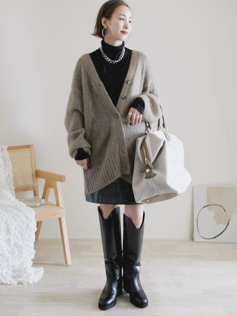 ベージュ系のカーディガン/ボレロ、ブラック系のスカート、ベージュ系のエコバッグ/サブバッグを着用したレディースの秋コーディネートの2枚目の写真