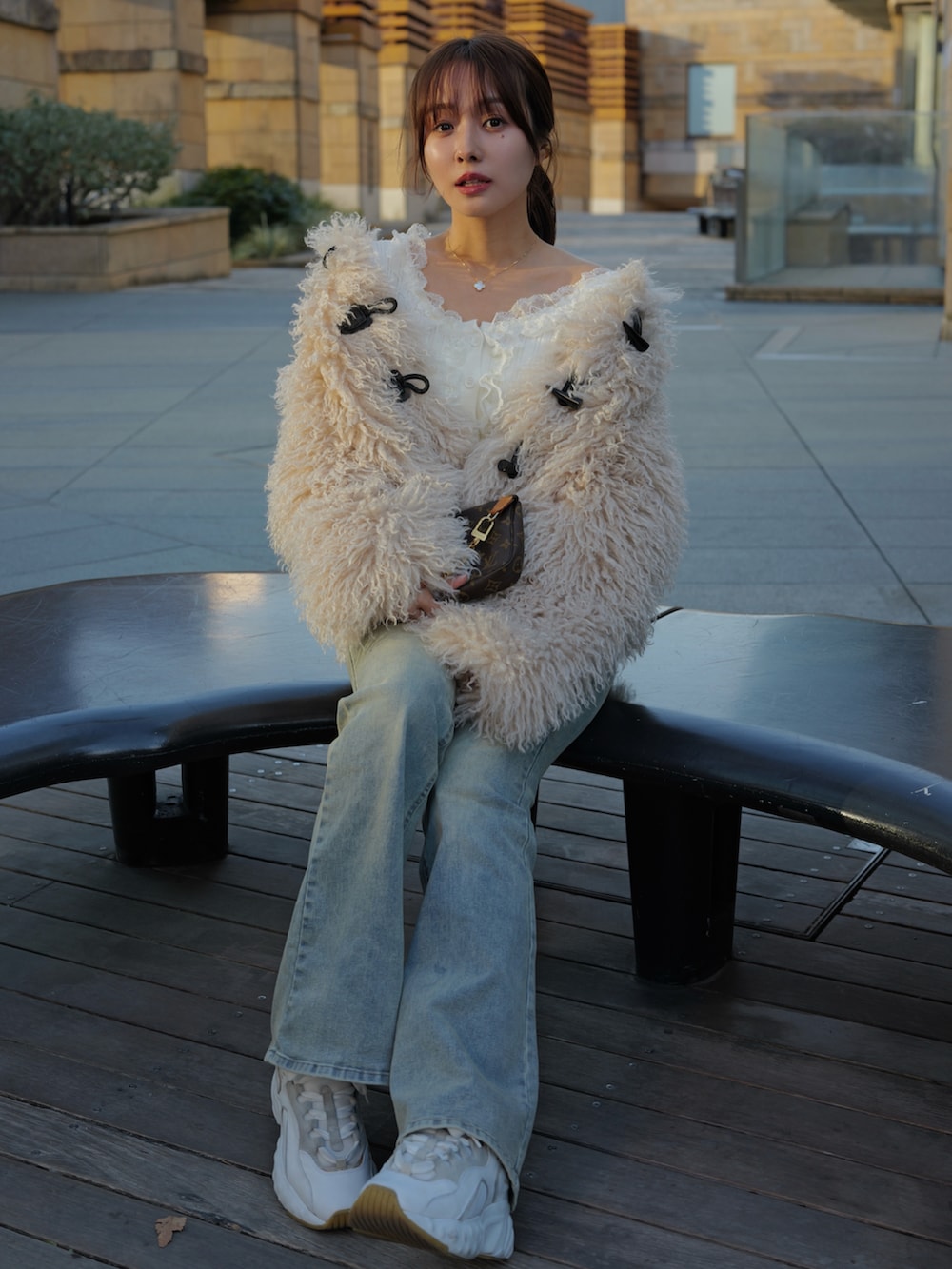 ホワイト系のトップス、ホワイト系のダッフルコート、ブルー系のデニムパンツを着用したレディースの冬コーディネートの2枚目の写真