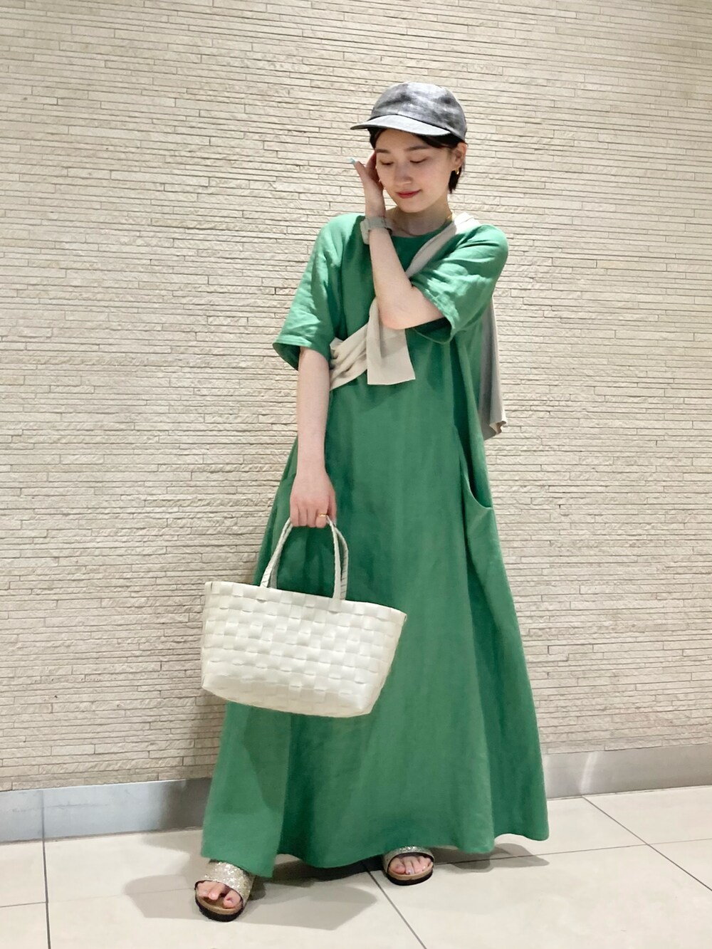 ベージュ系のかごバッグ、グリーン系のワンピース、ベージュ系のカーディガン/ボレロを着用したレディースの夏コーディネートの2枚目の写真