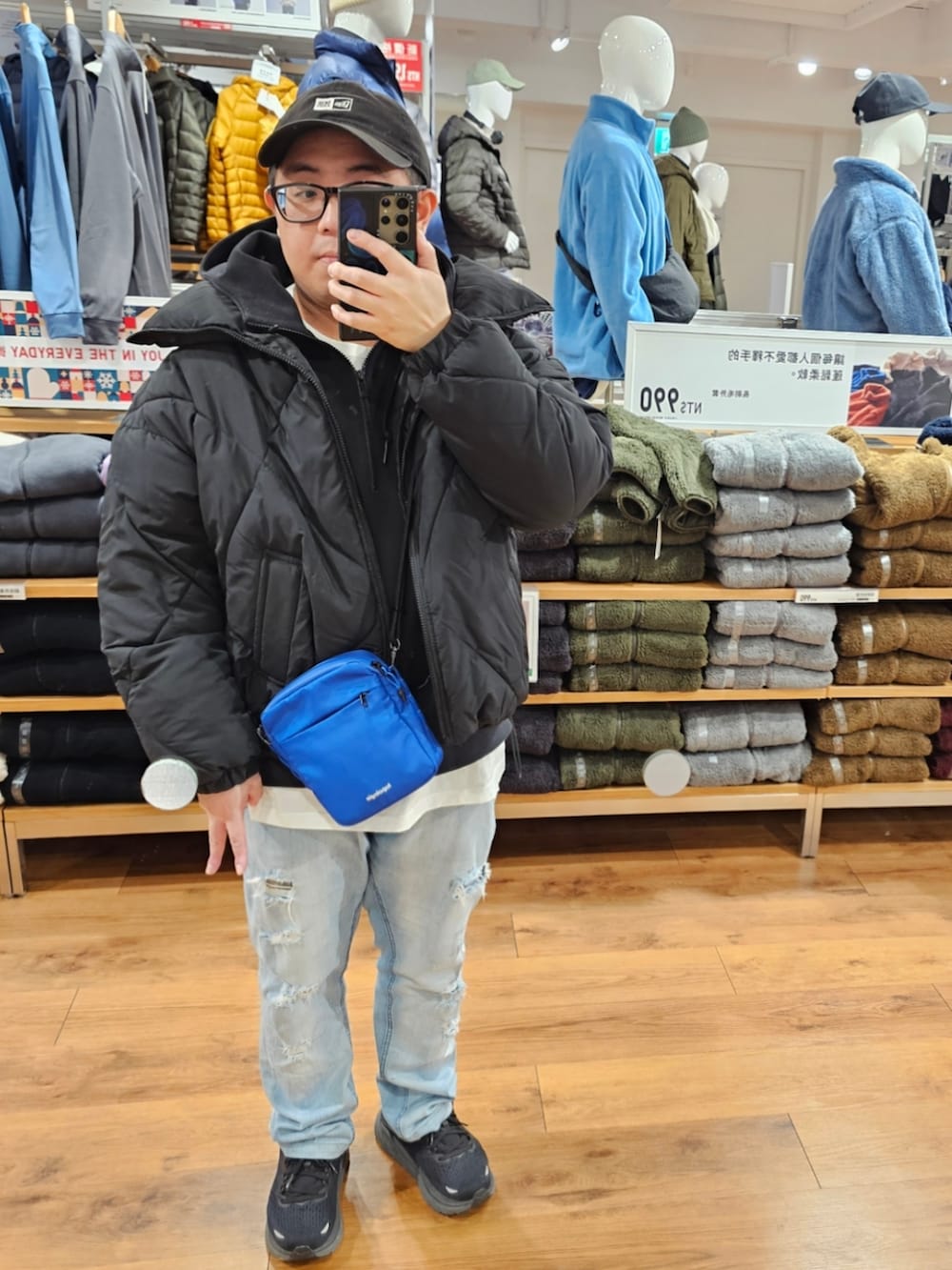 ブルー系のデニムパンツ、ブラック系のスニーカー、ブラック系のダウンジャケット/コートを着用したメンズの冬コーディネートの2枚目の写真