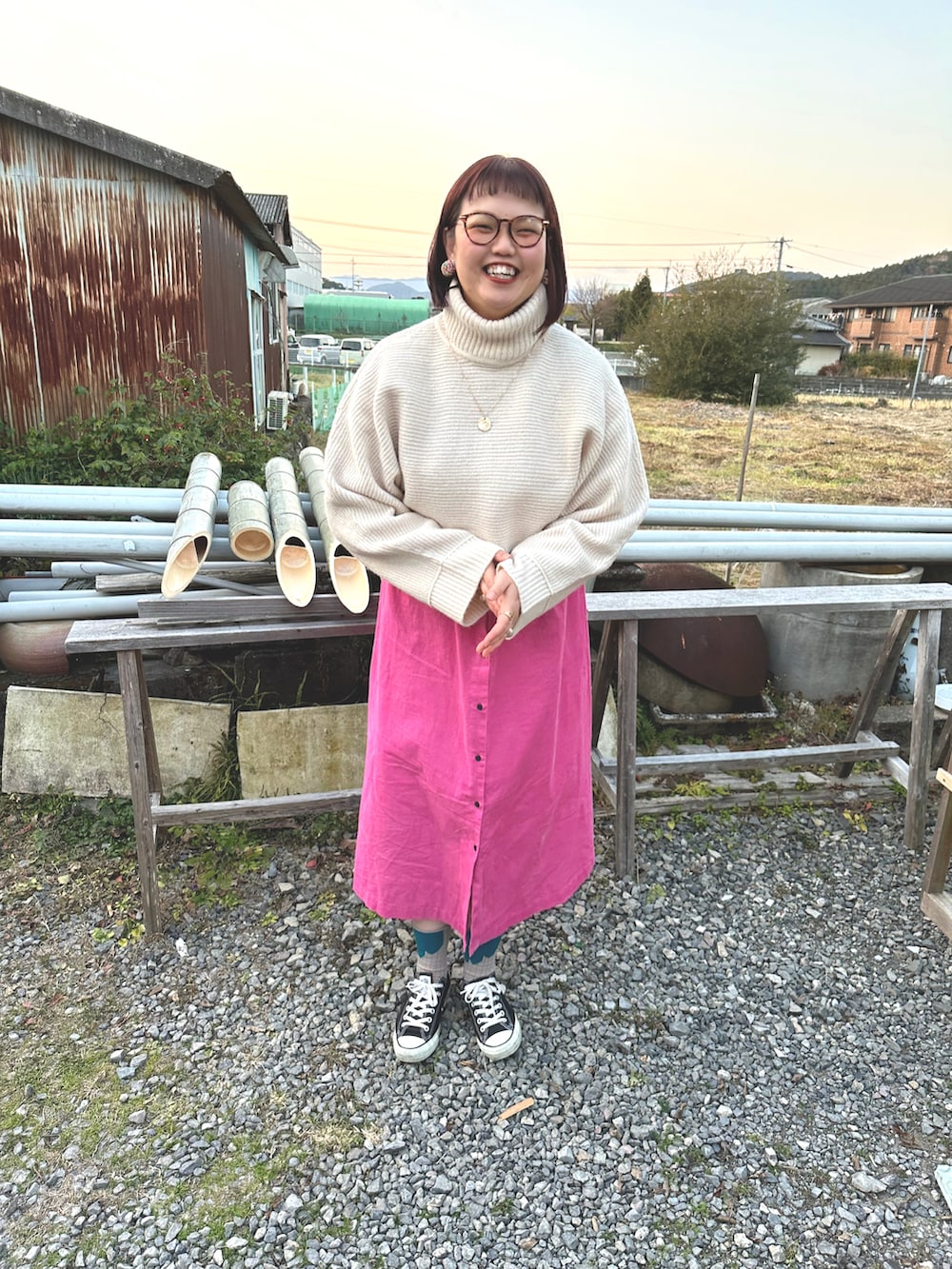ピンク系のワンピース、グリーン系のその他アウター、ブラック系のスニーカーを着用したレディースの冬コーディネートの2枚目の写真