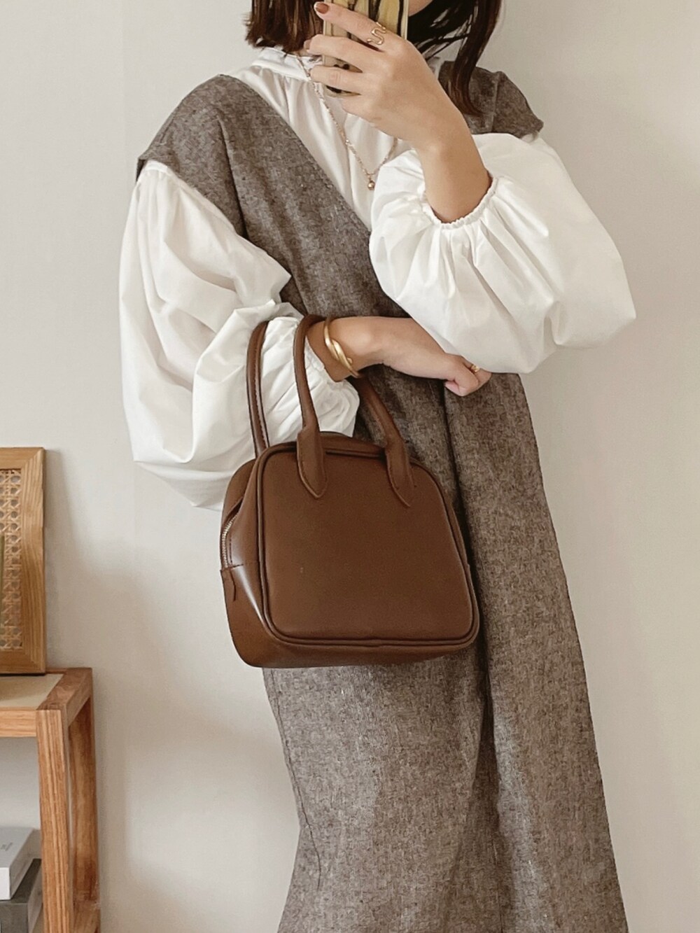 ホワイト系のシャツ/ブラウス、ブラウン系のボストンバッグ、ベージュ系のブーツを着用したレディースの秋コーディネートの3枚目の写真