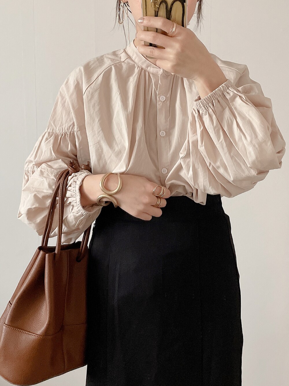 ブラック系のスカート、ブラウン系のショルダーバッグ、ベージュ系のサンダルを着用したレディースの春コーディネートの4枚目の写真