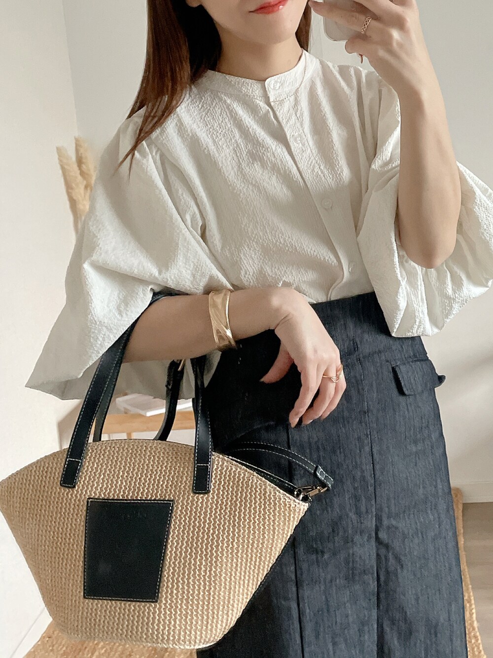 ホワイト系のシャツ/ブラウス、ブラック系のデニムスカートを着用したレディースの春コーディネートの2枚目の写真