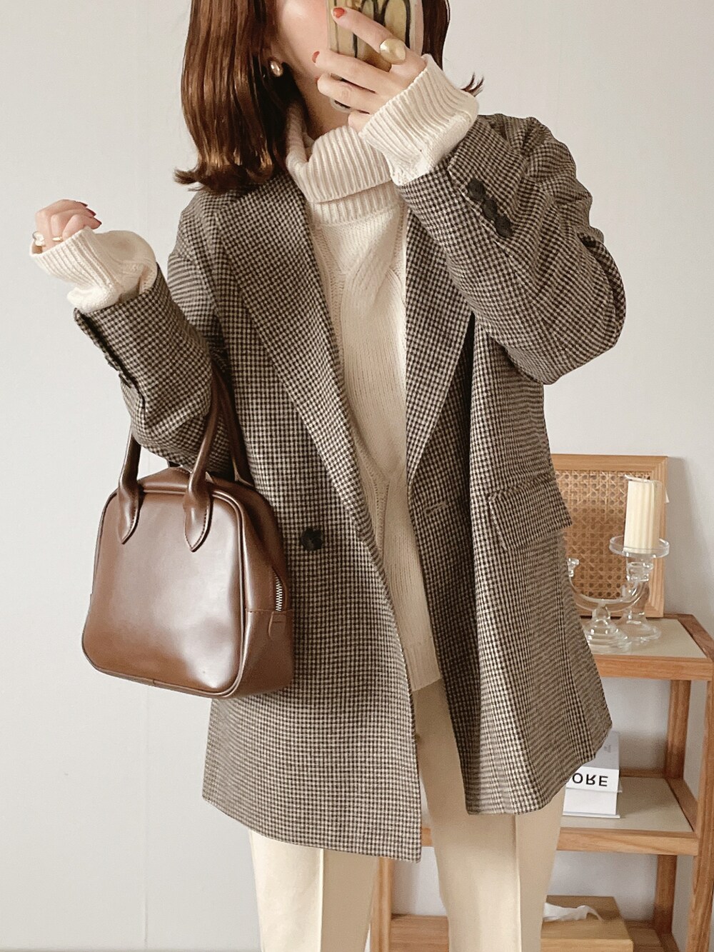 ブラウン系のテーラードジャケット、ブラウン系のボストンバッグ、ホワイト系のその他パンツを着用したレディースの秋コーディネートの2枚目の写真