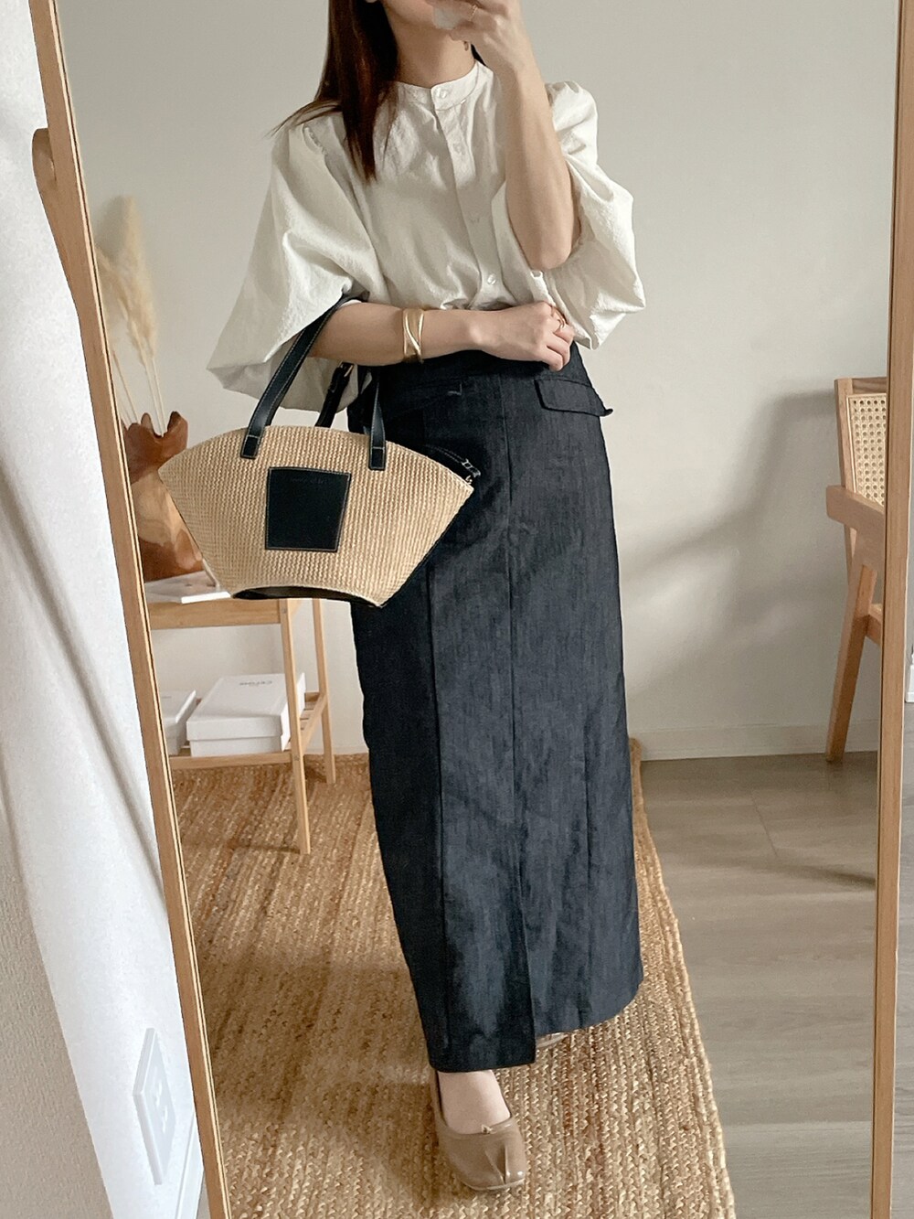 ホワイト系のシャツ/ブラウス、ブラック系のデニムスカートを着用したレディースの春コーディネートの3枚目の写真