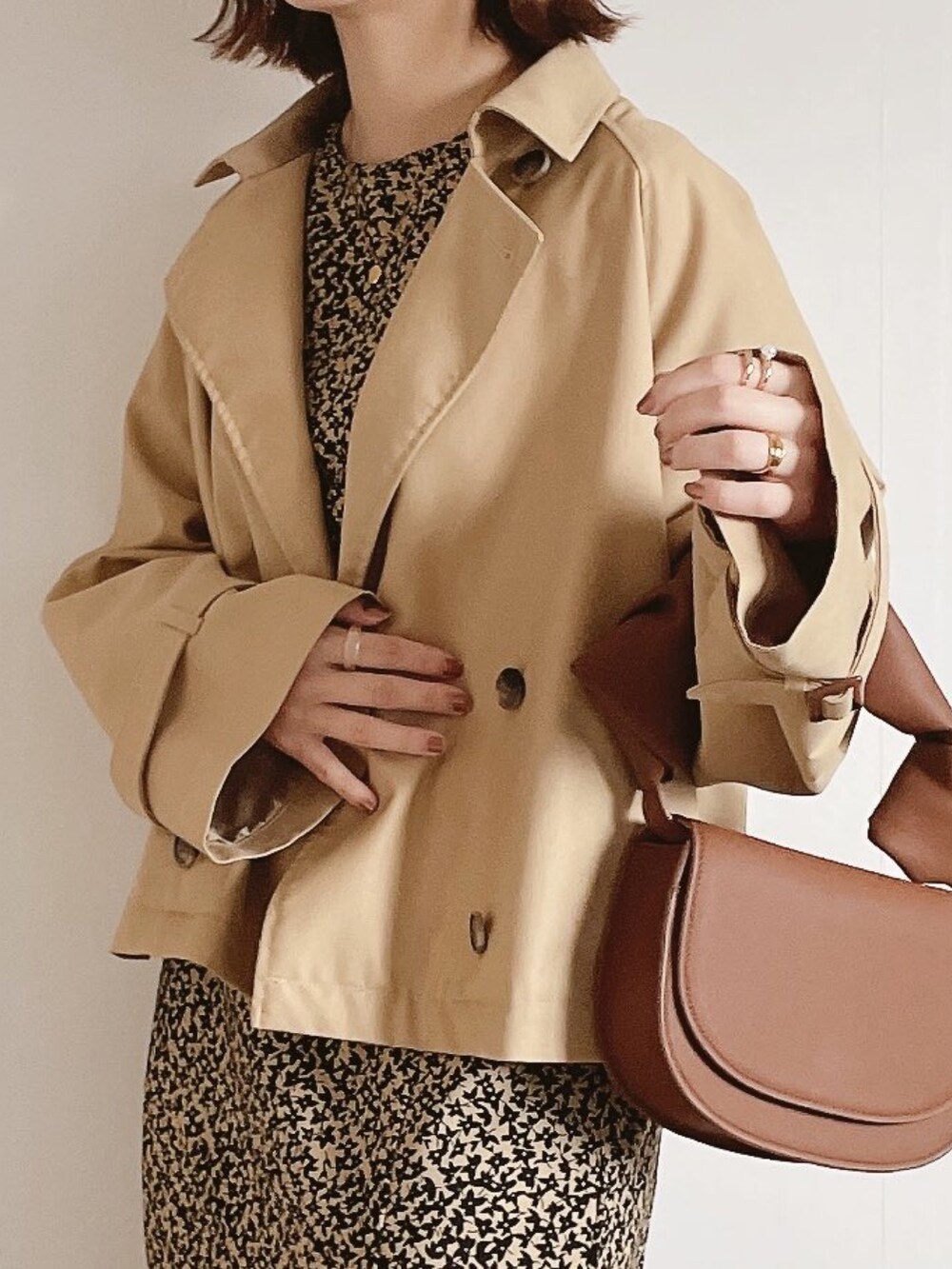 ベージュ系のワンピース、ブラウン系のショルダーバッグ、ブラウン系のパンプスを着用したレディースの冬コーディネートの2枚目の写真