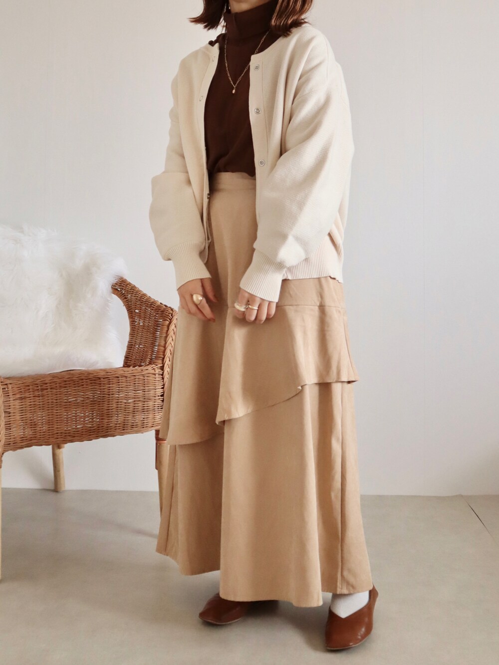 ベージュ系のスカート、ブラウン系のTシャツ/カットソー、ブラウン系のパンプスを着用したレディースの秋コーディネートの2枚目の写真