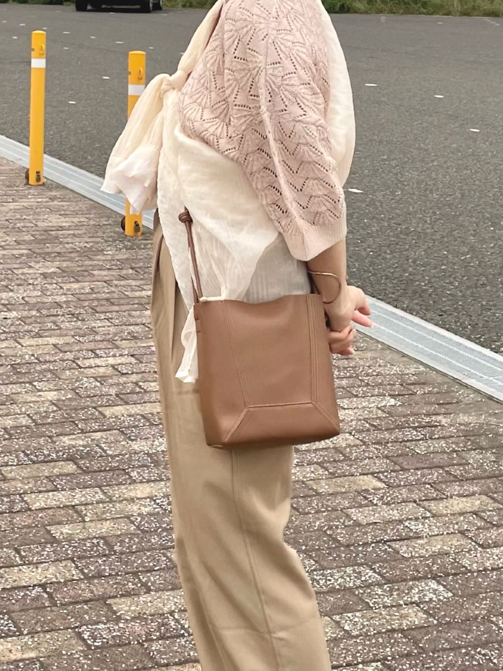 ベージュ系のその他パンツ、ベージュ系のサンダル、ベージュ系のショルダーバッグを着用したレディースの夏コーディネートの2枚目の写真