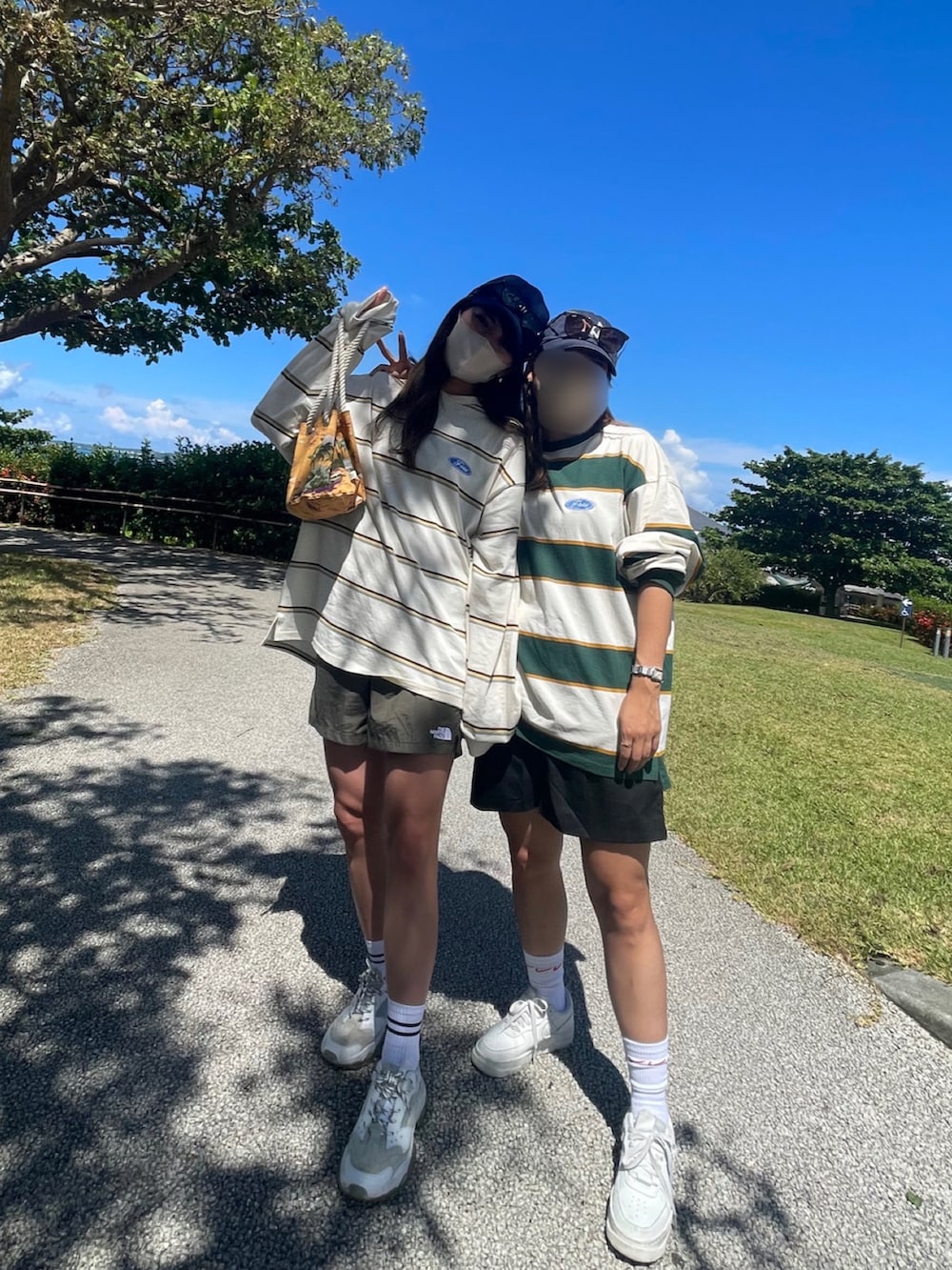 ホワイト系のスニーカー、オレンジ系のショルダーバッグ、ベージュ系のTシャツ/カットソーを着用したレディースの秋コーディネートの2枚目の写真