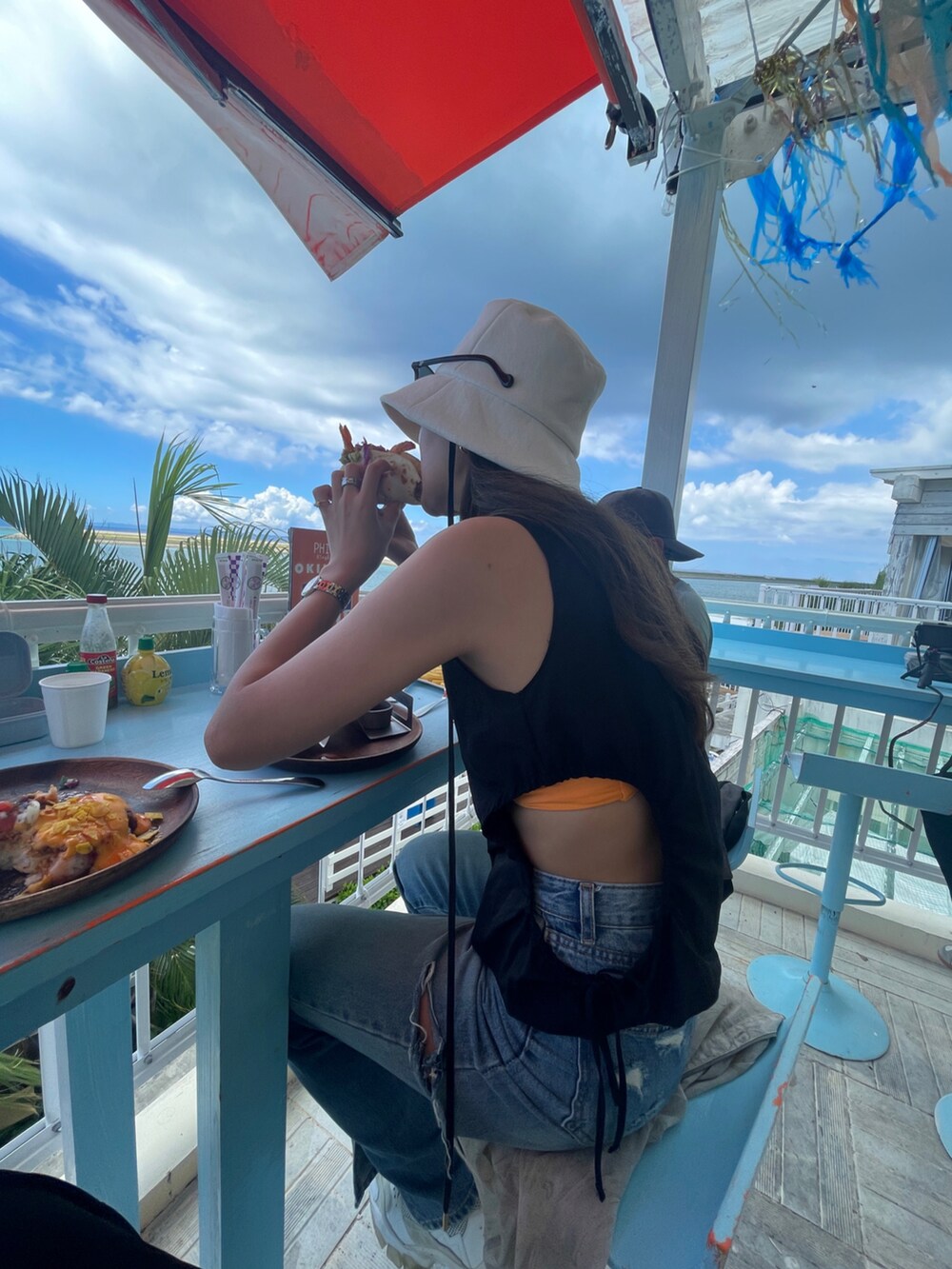 ブラック系のタンクトップ、ブラック系のショルダーバッグ、ホワイト系のスニーカーを着用したレディースの秋コーディネートの3枚目の写真