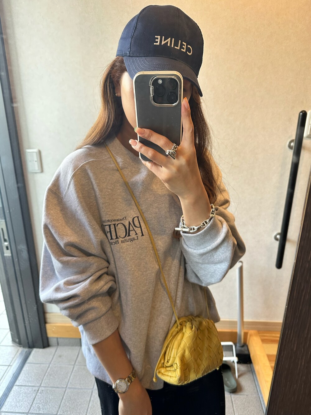 ブラック系のワンピース、ホワイト系のスニーカー、イエロー系のショルダーバッグを着用したレディースの春コーディネートの3枚目の写真