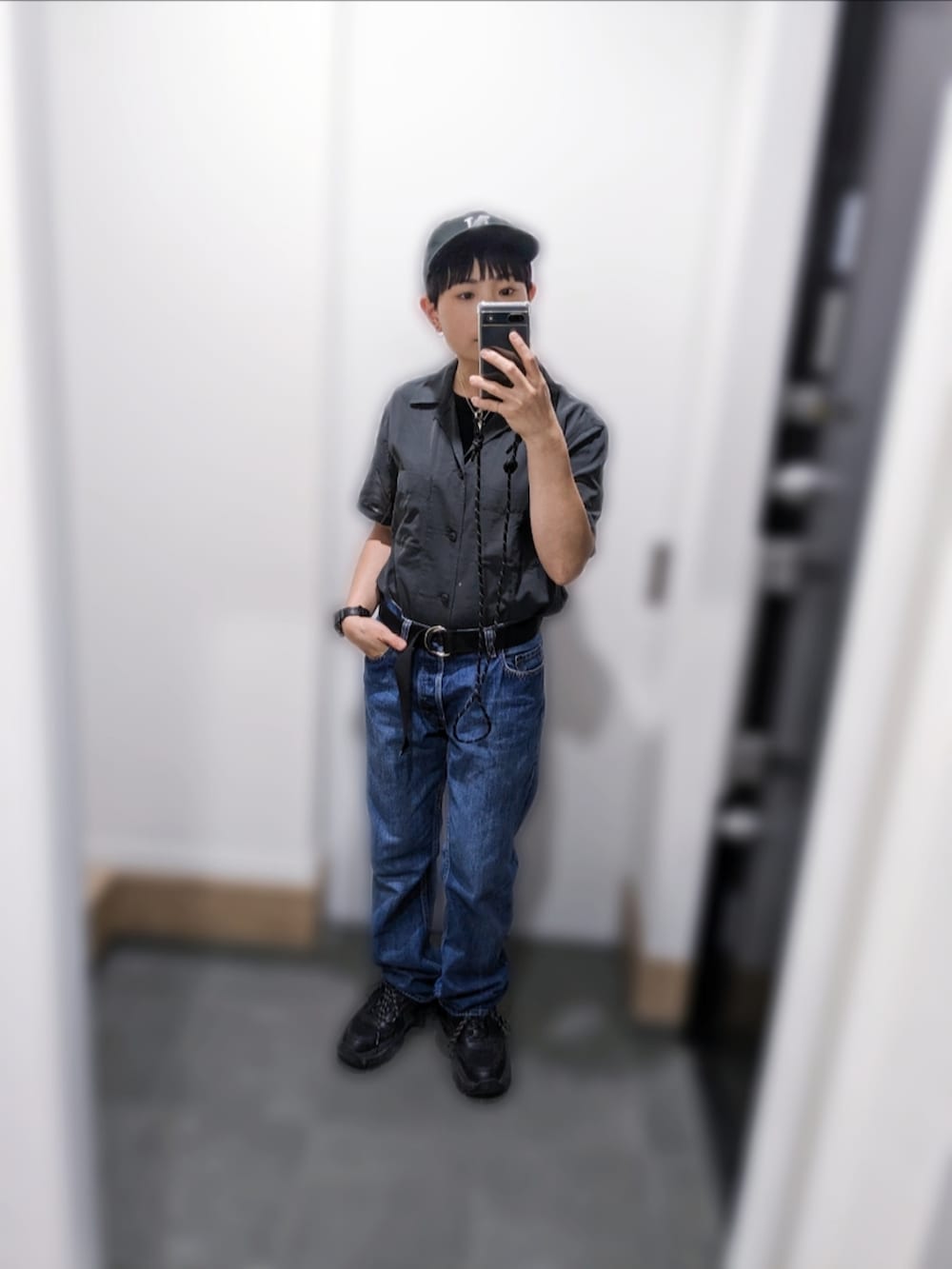 グレー系のシャツ/ブラウス、ブルー系のデニムパンツ、ブラック系のスニーカーを着用したレディースの夏コーディネートの2枚目の写真