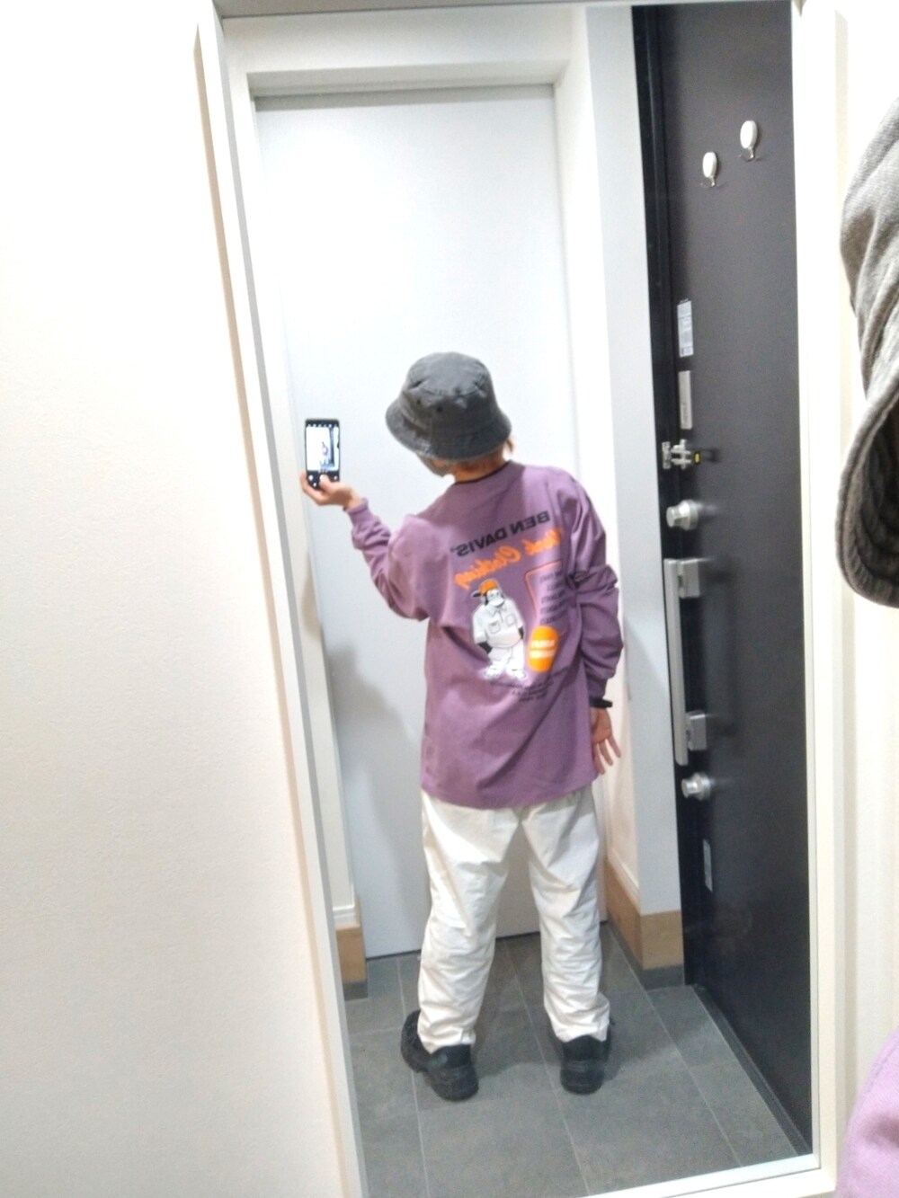 ホワイト系のデニムパンツ、パープル系のTシャツ/カットソー、ブラック系のスニーカーを着用したレディースの秋コーディネートの2枚目の写真