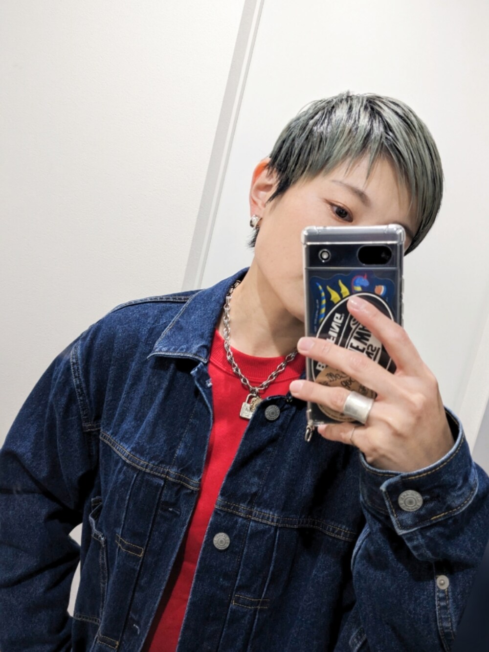 ブルー系のデニムジャケット、ブラック系のスラックス、ホワイト系のスニーカーを着用したレディースの秋コーディネートの2枚目の写真