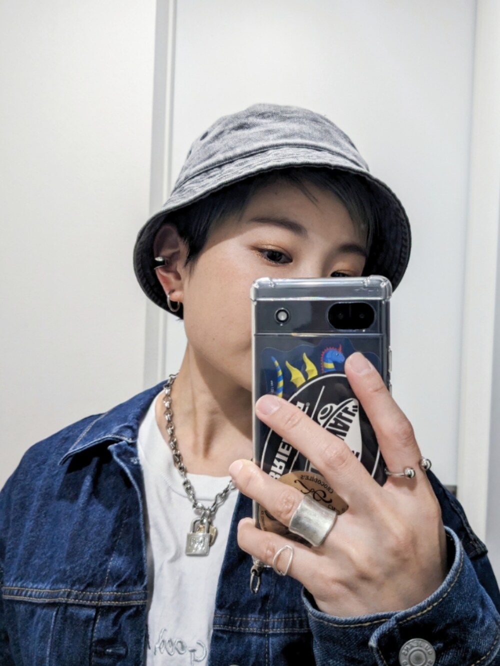 ブルー系のデニムジャケット、グレー系のデニムパンツ、ブラック系のブーツを着用したレディースの秋コーディネートの2枚目の写真