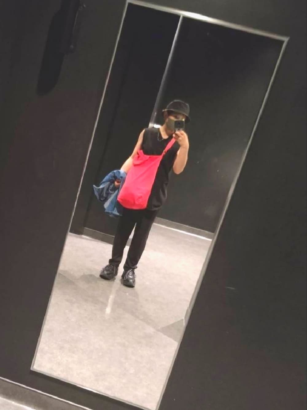 レッド系のトートバッグ、ブラック系のTシャツ/カットソー、ブラック系のスラックスを着用したレディースの春コーディネートの2枚目の写真