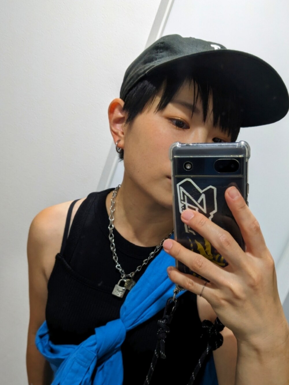 ブルー系のシャツ/ブラウス、ブラック系のワンピース、ホワイト系のスニーカーを着用したレディースの夏コーディネートの2枚目の写真