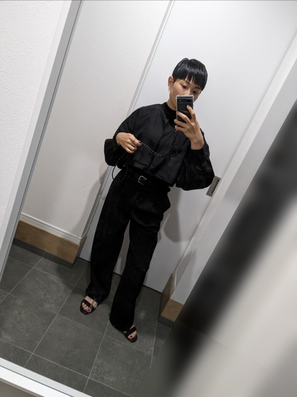 ブラック系のシャツ/ブラウス、ブラック系のスラックス、ブラック系のサンダルを着用したレディースの夏コーディネートの2枚目の写真