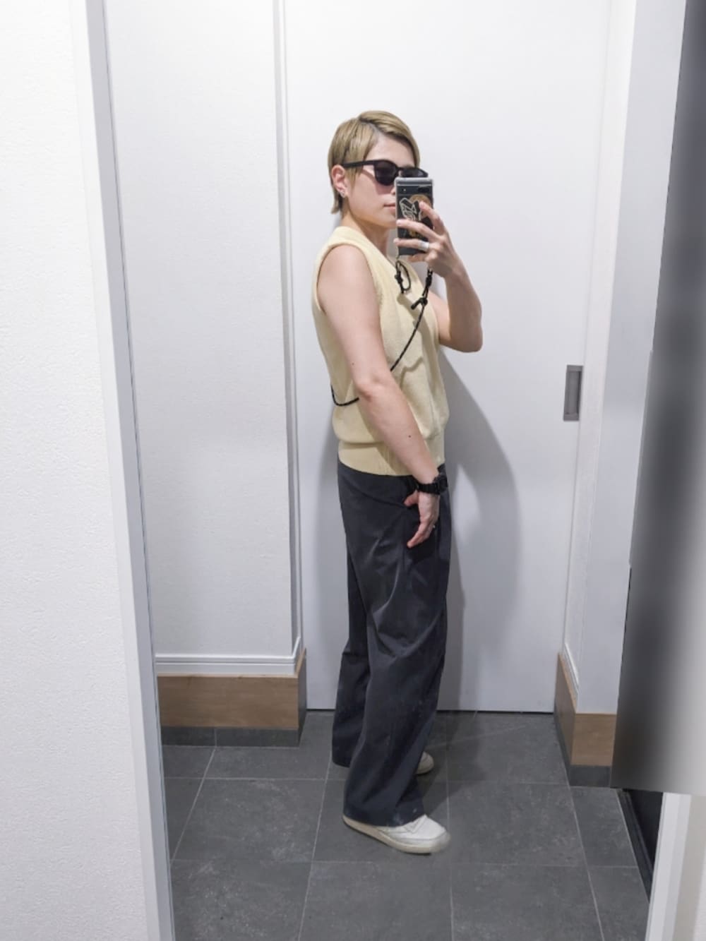 ベージュ系のニット/セーター、ブラック系のスラックス、ホワイト系のスニーカーを着用したレディースの秋コーディネートの2枚目の写真