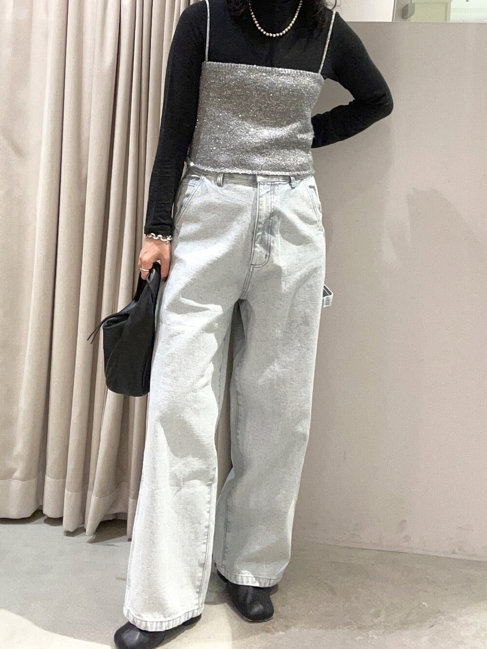 ブラック系のその他シューズ、ブルー系のデニムパンツ、ブラック系のバッグを着用したレディースの秋コーディネートの2枚目の写真