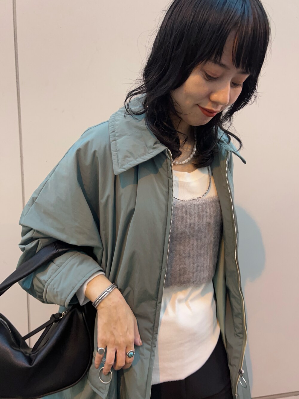 グリーン系のその他アウター、ブラウン系のブーツ、グレー系のニット/セーターを着用したレディースの秋コーディネートの4枚目の写真