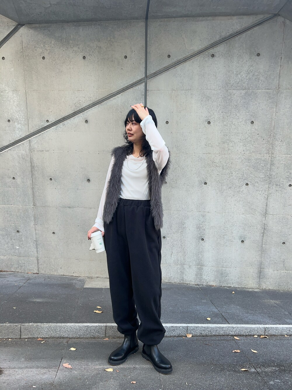 ブラック系のその他パンツ、ホワイト系のTシャツ/カットソー、グレー系のベストを着用したレディースの秋コーディネートの2枚目の写真