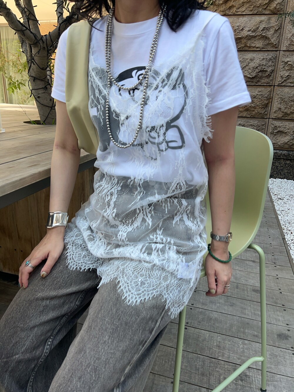 ホワイト系のシャツ/ブラウス、イエロー系のトートバッグ、ブラウン系のデニムパンツを着用したレディースの夏コーディネートの3枚目の写真